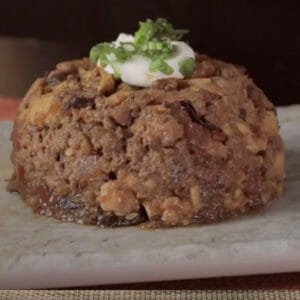 Platillo final de Chilli de Chorizo de lomo de cerdo Chata servido con crema y cebollín