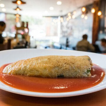 Disfruta de un rico chile capeado relleno de queso, sabor irresistible en cada bocado.